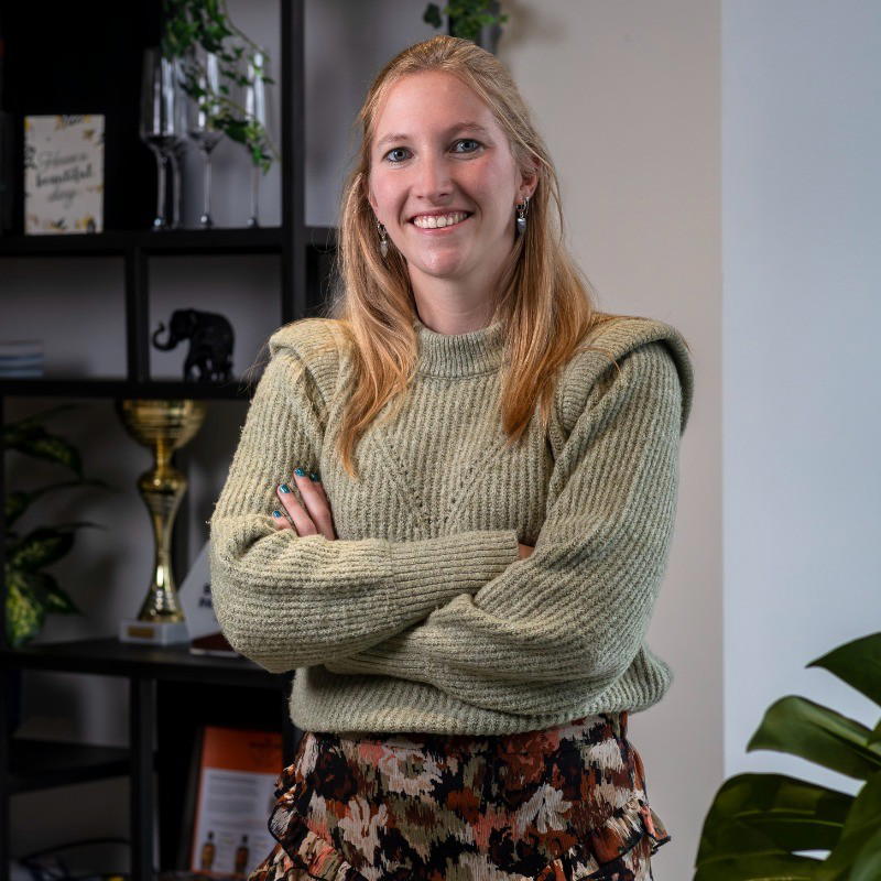 Linda - Woman with blond hair and green sweater is smiling.